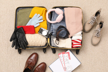 Canvas Print - Open suitcase with warm clothes, accessories and shoes on floor, flat lay