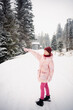 © Анна Молько - girl in a pink jacket and hat walks in the snowy forest