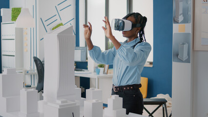 Poster - Woman architect wearing vr glasses to design construction layout and building model. Builder planning real estate project with virtual reality headset and maquette. Architecture plan
