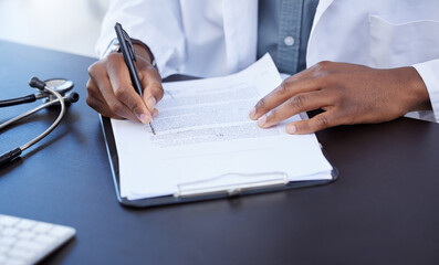 Poster - Going over some paperwork. Closeup shot of a male doctor filling out paperwork.