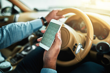Poster - Doing a quick check in with his schedule. Closeup shot of an unrecognisable businessman using a cellphone while driving.