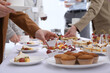 © New Africa - People near table with different delicious snacks during coffee break, closeup