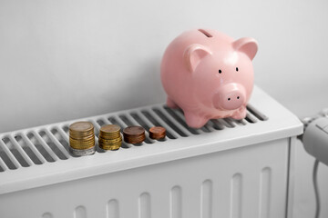 Wall Mural - heating, energy crisis and consumption concept - piggy bank with money on radiator at home