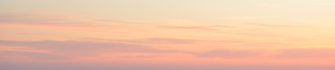 Clear blue sky. glowing pink and golden cirrus and cumulus clouds after storm, soft sunlight. Dramatic sunset cloudscape. Meteorology, heaven, peace, graphic resources, picturesque panoramic scenery