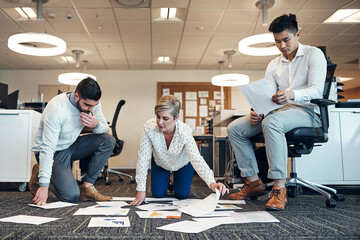 Aufkleber - Being productive with paperwork. Shot of businesspeople working on paperwork together on the floor in the office.