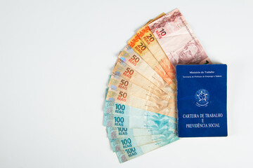 Brazilian document work and social security (Carteira de Trabalho e Previdencia Social) with Brazilian money banknotes