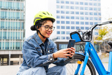 Ethnic Lady Using Smartphone Near Bicycle On Urban Street