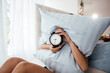 © Надія Коваль - Too lazy to get out of bed, a woman covers her face with a pillow. Early wake up, not getting enough sleep, going work concept