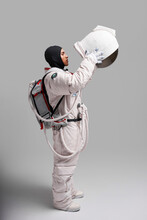 Astronaut Taking Off Helmet Of Spacesuit In Studio