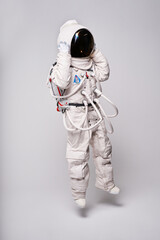 Anonymous astronaut in spacesuit and helmet in studio