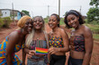 Group of smiling African lesbian girls together with the rainbow flag get together, LGBTQ + in africa