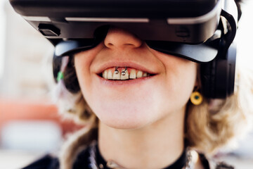 Diverse young pierced woman toothy smile enjoying augmented reality wearing vr headset videogaming metaverse 5g technology