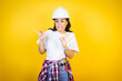 Young caucasian woman wearing hardhat and builder clothes over isolated yellow background disgusted expression, displeased and fearful doing disgust face because aversion reaction.Annoying concept