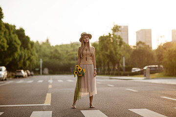 Wall Mural - Portrait of beautiful woman with sunflowers outdoor at summer