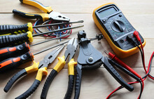 Different Electrical Tools For Repair And Maintenance On Wooden Background Closeup.