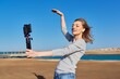 © Valerii Honcharuk - Middle-aged woman recording video on smartphone with outdoor on seashore