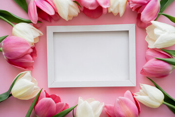 Canvas Print - top view of colorful tulips around frame on pink.