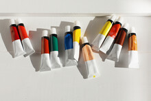 Acrylic Paints In Tubes On Empty Copy Space White Wood Background. Flat Lay, Top View.