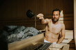 © BGStock72 - Young man pouring water onto hot stone in the sauna