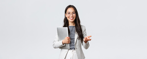 Wall Mural - Business, finance and employment, female successful entrepreneurs concept. Smiling professional businesswoman, real estate broker showing clients good deal, carry laptop in hand