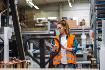 Wall Mural - Woman with tablet in factory storehouse checking location of goods