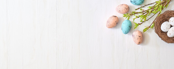 Wall Mural - branches with green leaves and easter eggs on a light background. happy easter flat lay concept