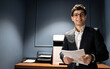 © muse studio - A financier with glasses in a suit holds documents works in an office coworking space