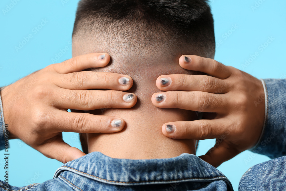 Man with stylish manicure holding hands behind his head on color background