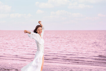 Sticker - Stylish young woman posing near pink lake on summer day