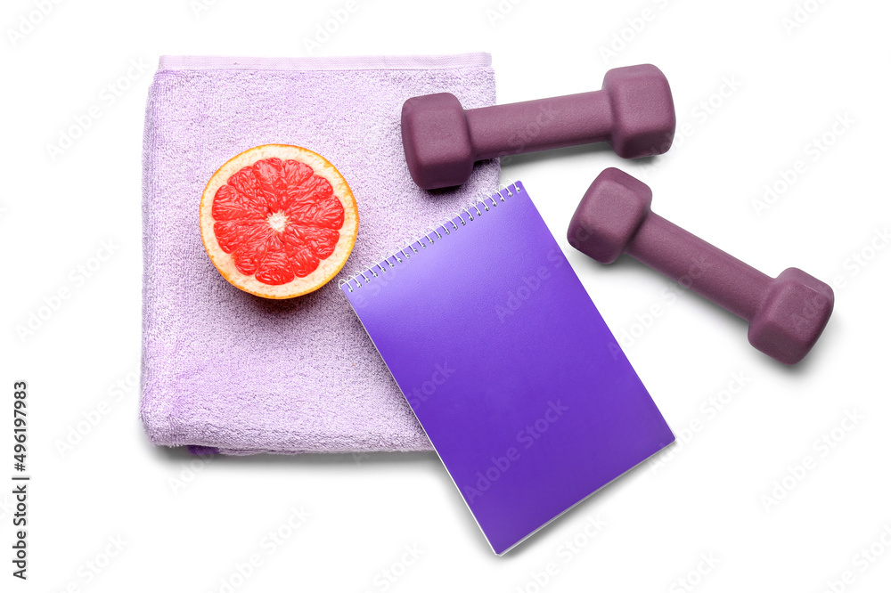 Stylish dumbbells, grapefruit, notebook and towel on white background