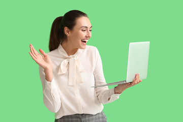 Sticker - Happy young businesswoman using laptop on green background