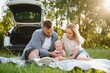 © Serhii - Family in a forest. People by the car. Sunset background.