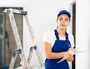 Portrait of builder woman who checks the completed work on