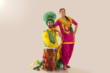 Sikh Couple Posing With Their Elbows Resting On Drum And Shoulder During Baisakhi Celebration