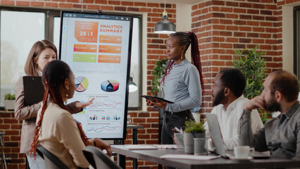Wall Mural - Business people talking about business strategy and project, using analysis on monitor at financial presentation. Women talking to colleagues about company development and growth.