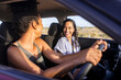 © Rido - Smiling multiethnic woman friends enjoying road trip in car
