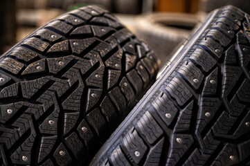 close-up of snow tire with metal studs, which improve traction on icy surfaces, studded winter tyre