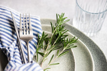 Close-up Of A Place Setting With A Sprig Of Fresh Rosemary