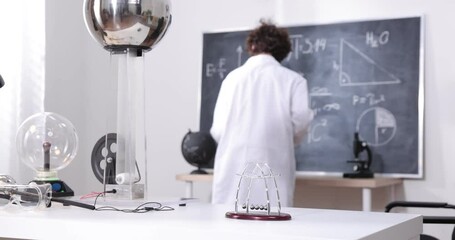 Wall Mural - a boy conducts physical experiments with electricity, a plasma ball, and a van de graaff generator.