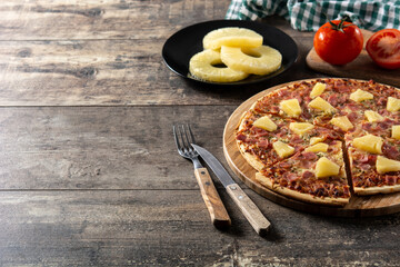 Canvas Print - Hawaiian pizza with pineapple,ham and cheese on wooden table	