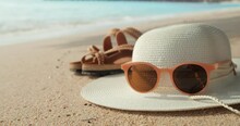 Summer Beach With Straw Hat, Sunglasses And Flip Flops On Sandy Beach Background.