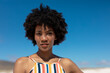 © wavebreak3 - Portrait of confident young african american woman with afro hairstyle against blue sky