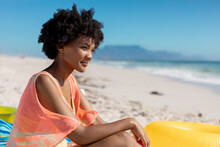 African American Woman With Black Afro Hairstyle Sitting At Beach Enjoying Summer Holiday
