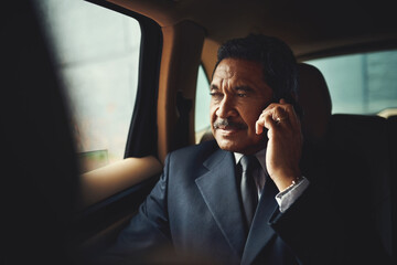 Poster - the first business call of the day. shot of a mature businessman using his phone while traveling in 