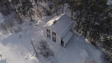 Aerial View Of New White Modern Residential House Cottage In A Nice Neighborhood Next To The Forest. Metal Roof. Trees Grow On The Land. Around The Snow And Snowdrifts. Two-storey House
