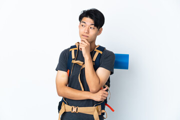 Wall Mural - Mountaineer Chinese man with isolated on white background having doubts and thinking