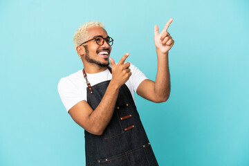 Poster - Restaurant Colombian waiter man isolated on blue background pointing with the index finger a great idea