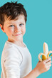 © ADDICTIVE STOCK - Cheerful boy with ripe banana