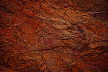 Red Brown Rock Texture. Cracked Mountain Surface. Close-up. Stone Background With Space For Design. Rusty Grunge Backdrop.