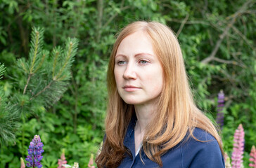 portrait of a young girl in lupins in the forest